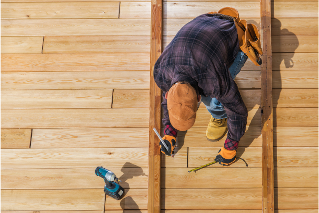 Building Wooden Deck by worker with power tools